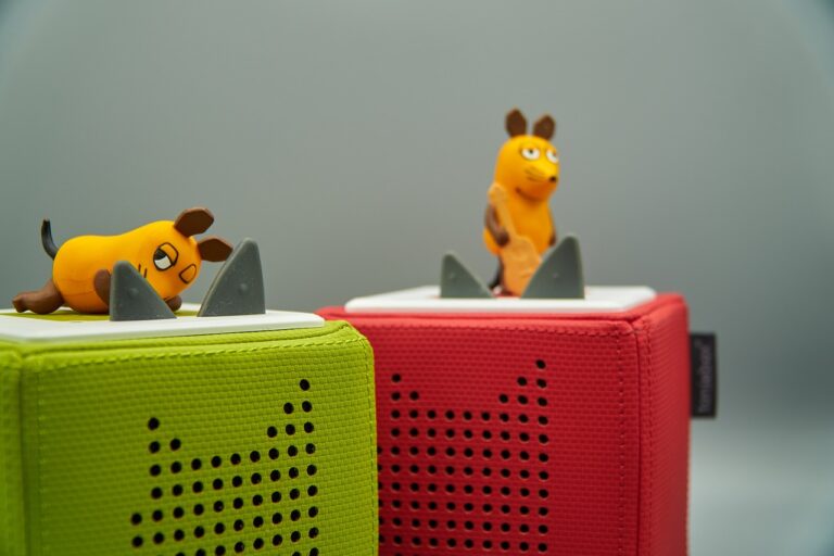 Kind spielt neben Eltern beim Simracing mit der bunten Toniebox